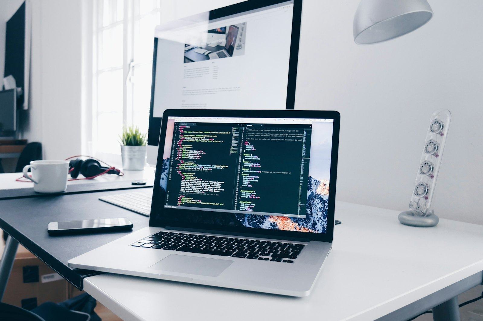 Laptop with code on a desk in a modern workspace