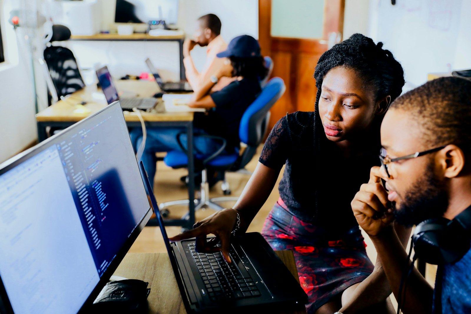 Two engineers reviewing work at a monitor
