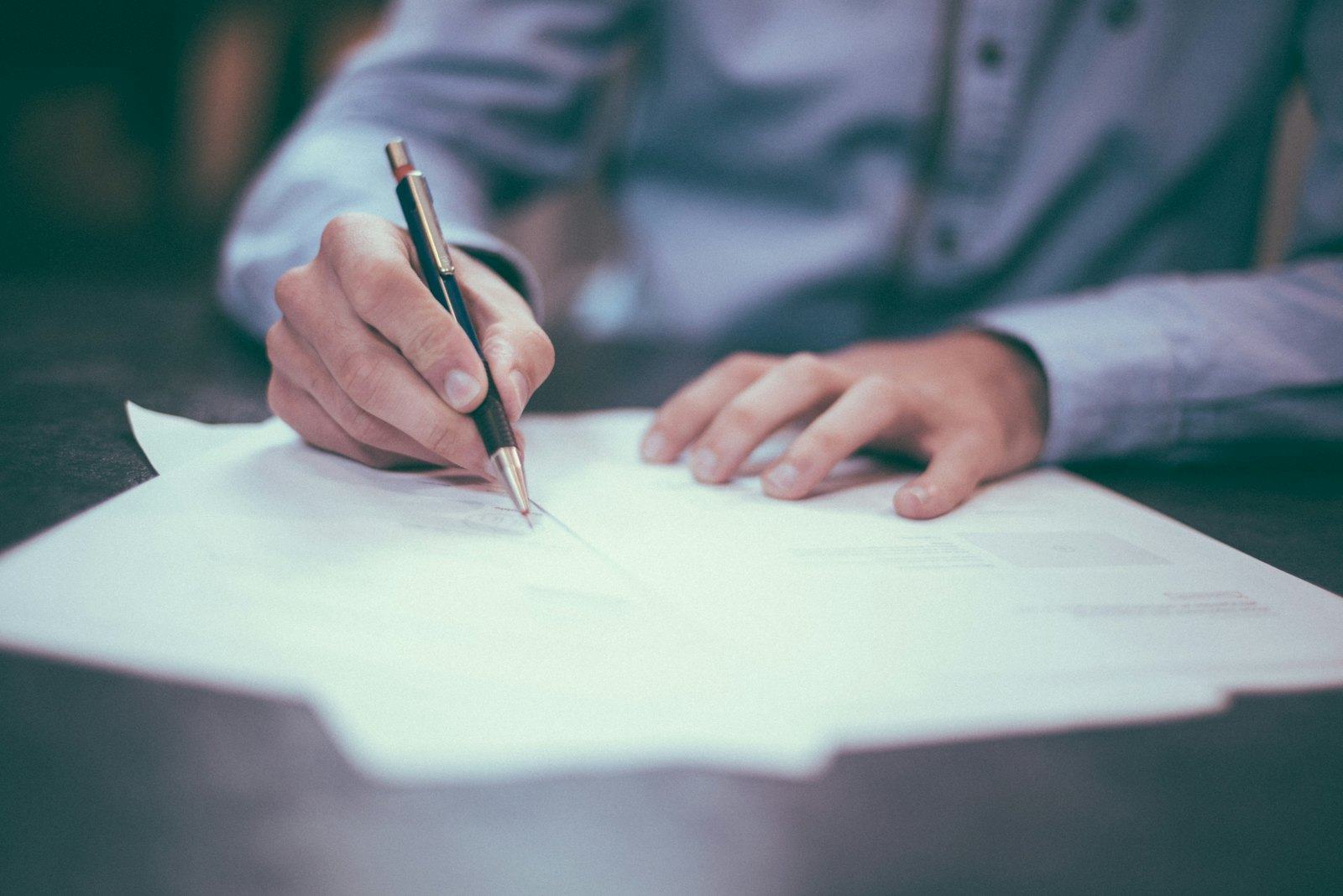 A written note being drafted at a desk
